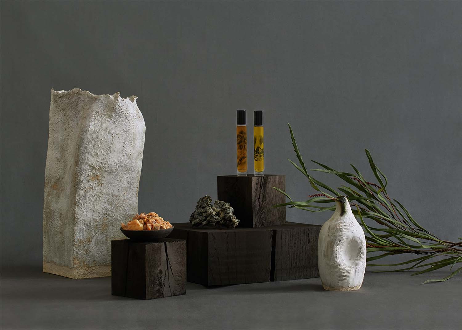 Colpo dell'onda and Nebbia all'alba scented oils for energy and calm shot on solid cedar blocks with hand-made ceramics vessels, benzoin and a branch